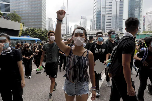Protesters march to surround the police headquarters in Hong Kong on Friday, June 21, 2019. Several hundred mainly student protesters gathered outside Hong Kong government offices Friday morning, with some blocking traffic on a major thoroughfare, after a deadline passed for meeting their demands related to controversial extradition legislation that many see as eroding the territory's judicial independence. (Photo by Kin Cheung/AP Photo)