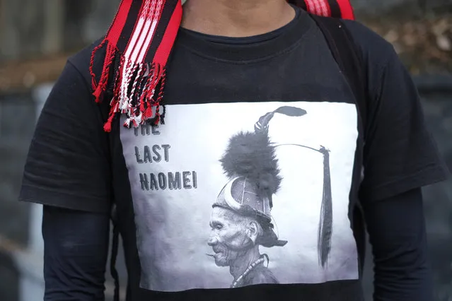 Manpong Konyak, 23, from Oting village, wears a traditional scarf and a t-shirt showing a portrait of his tribesman that reads “the last warrior” during a gathering at the end of a 70-kilometer (43 miles) walk demanding the repeal of the Armed Forces Special Powers Act (AFSPA) in Kohima, in the northeastern Indian state of Nagaland, Tuesday, January 11, 2022. “We want peace. We do not want violence. AFSPA must be repealed because we are a peace-loving people”, Manpong said. Fourteen civilians were killed by the Indian army in December, twelve of them from Oting village. (Photo by Yirmiyan Arthur/AP Photo)