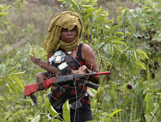 A female member of the anti-balaka, a Christian militia, patrols with other militiamen outside village of Zawa April 8, 2014. (Photo by Goran Tomasevic/Reuters)