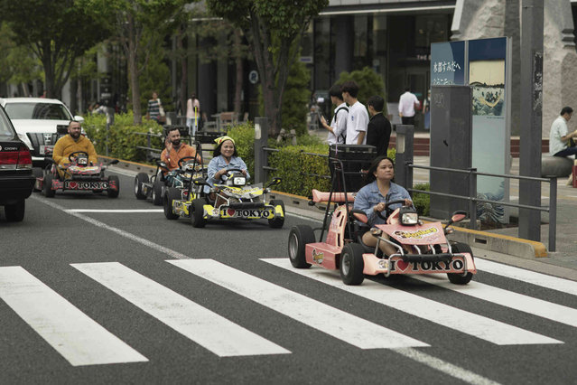 Tourists ride go-carts in a tour during a holiday period called, “Golden Week”, in Tokyo, Tuesday, April 30, 2024. Golden Week is a popular time for travels, festivals and other entertaining events throughout Japan. (Photo by Hiro Komae/AP Photo)