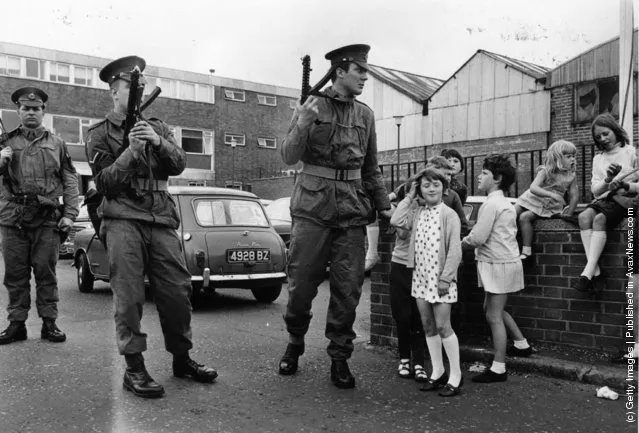 1970:  Armed British soldiers impose a curfew on the Falls Road in Belfast