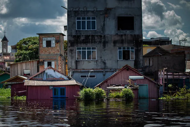 Photograph of the flooded houses in the “Igarape do Sao Vicente”, a stream that ends in the Negro River, in Manaus, Brazil, 31 May 2021. The Negro river flood reached 29.98 meters and became the largest in 119 years of measurement. The historic flooding is caused by the high volume of rains in the first months of 2021. (Photo by Raphael Alves/EPA/EFE)
