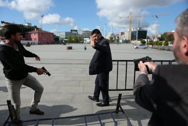 Plain clothes police officers point their guns at an assailant who attempted to shoot prominent Turkish journalist Can Dundar, outside a courthouse in Istanbul, Turkey May 6, 2016. (Photo by Can Erok/Reuters/Cumhuriyet)