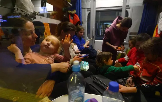 Refugees sit inside a train to Berlin at the main train station, after fleeing the Russian invasion of Ukraine in Krakow, Poland, March 15, 2022. (Photo by Fabrizio Bensch/Reuters)
