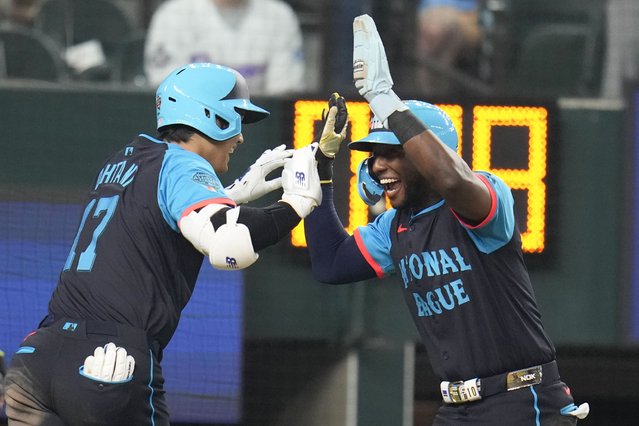 National League's Shohei Ohtani, of the Los Angeles Dodgers, left, celebrates his three-run home with Jurickson Profar, of the San Diego Padres, in the third inning during the MLB All-Star baseball game, Tuesday, July 16, 2024, in Arlington, Texas. (Photo by Julio Cortez/AP Photo)