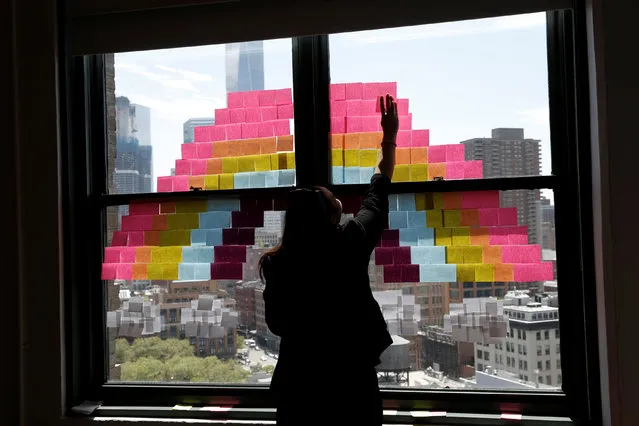 An employee creates a rainbow image on a window with Post-it notes at the Horizon Media offices at 75 Varick Street in lower Manhattan, New York, U.S., May 18, 2016. (Photo by Mike Segar/Reuters)