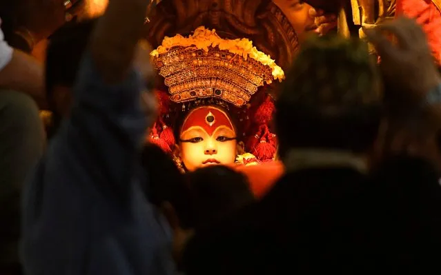 A Nepali child revered as a living goddess or Kumari, is carried in a chariot during a procession on the last day of the Indra Jatra festival at Basantapur Durbar Square in Kathmandu on September 17, 2019. The eight-day festival celebrates Indra, the king of gods and god of rains. During this festival, Kumari, the living goddess, is also taken around parts of the capital city in a religious procession. (Photo by Prakash Mathema/AFP Photo)