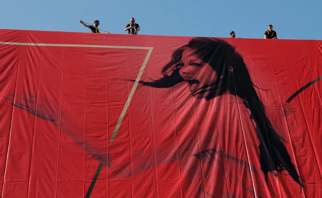 A picture taken on May 15, 2017 in Cannes, southeastern France, shows the affiche for the 70 th Cannes Film Festival hanging from the facade of the Palais des Festivals along the top end of The Croisette. Legendary Italian Tunisian film actress Claudia Cardinale (born 1938) graces this year’s affiche as she dances on a Roman rooftop in 1959. (Photo by Eric Gaillard/Reuters)