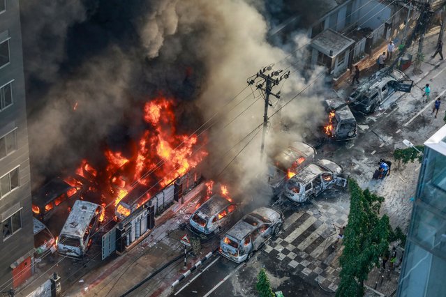 Smoke rises from the burning vehicles after protesters set them on fire near the Disaster Management Directorate office, during the ongoing anti-quota protest in Dhaka on July 18, 2024. Bangladeshi students set fire to the country's state broadcaster on July 18, a day after Prime Minister Sheikh Hasina appeared on the network seeking to calm escalating clashes that have killed at least 32 people. (Photo by AFP Photo/Stringer)