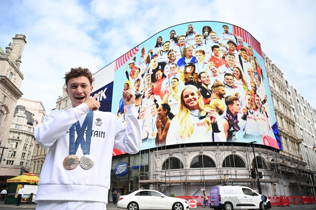 Olympic Diver Noah Williams poses with his Paris 2024 silver and bronze medals at Piccadilly Circus on August 14, 2024 in London, England. A large-scale display featuring 50 Olympians, including medalists Noah Williams, Keely Hodgkinson, and Andy Murray, lit up Piccadilly Lights, with similar displays appearing in 12 other UK cities. (Photo by Leon Neal/Getty Images)