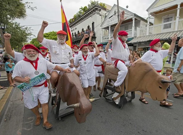 Participants in the annual Ernest Hemingway Look-Alike Contest proceed on Duval Street during the annual “Running of the Bulls” in this handout photo provided the Florida Keys News Bureau, in Key West, Florida, July 25, 2015,  The whimsical and much safer answer to the event's namesake in Pamplona, Spain, was staged as a facet of the island city's annual Hemingway Days festival that ends Sunday. Hemingway lived and wrote in Key West throughout the 1930s. (Photo by Andy Newman/Reuters/Florida Keys News Bureau)
