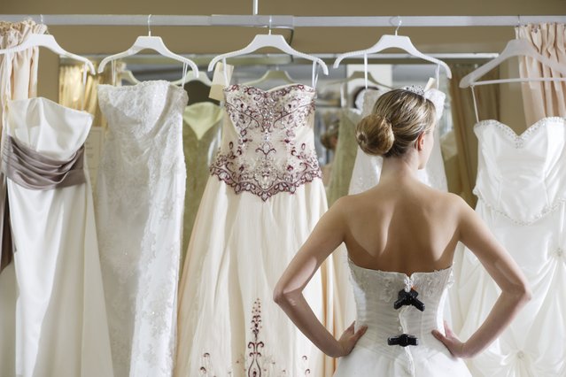 Bride looking at rack of dresses. (Photo by Peter Cade/Getty Images)