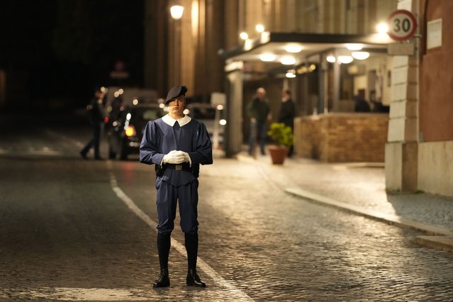 A Swiss Guard officer patrols the Santa Anna gate at the Vatican, late Thursday, May 18, 2023. A car driven by someone with apparent psychiatric problems rushed through Santa Anna gate Thursday evening and sped past Swiss Guards into a palace courtyard before the driver was apprehended by police. Vatican gendarmes fired a shot at the speeding car's front tires after it rushed the gate, but the vehicle managed to continue on its way, the Vatican press office said in a statement late Thursday. (Photo by Andrew Medichini/AP Photo)