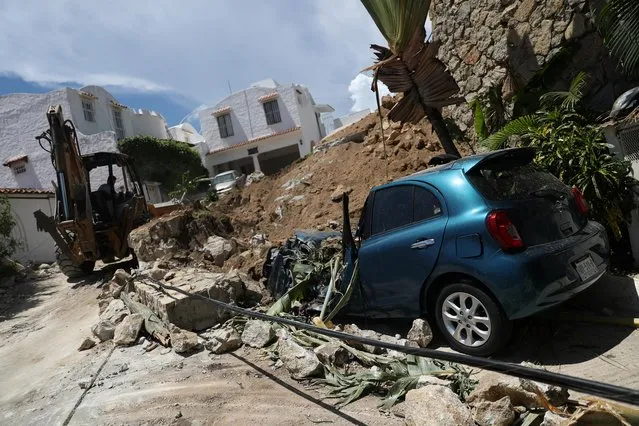 A landslide and a damaged car are pictured in the aftermath of the earthquake in Acapulco, In Guerrero state, Mexico, September 8, 2021. (Photo by Edgard Garrido/Reuters)
