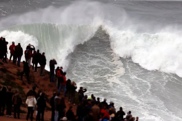 People gather to watch big waves at Praia do Norte in Nazare, Portugal on December 22, 2019. (Photo by Rafael Marchante/Reuters)