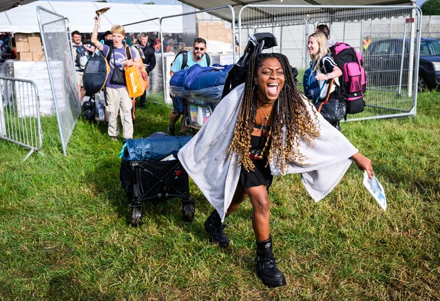 Revellers celebrate as they pass through gates after the 8am public opening of the campsites on Day 1 of Glastonbury Festival 2023 on June 21, 2023 in Glastonbury, England. (Photo by Leon Neal/Getty Images)