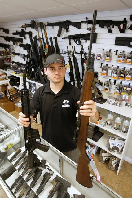 Salesman Ryan Martinez holds an AR-15, (L) and a Springfield M1-A, (R) both semi-automatics guns at the “Ready Gunner” gun store in Provo, Utah, U.S., June 21, 2016. (Photo by George Frey/Reuters)