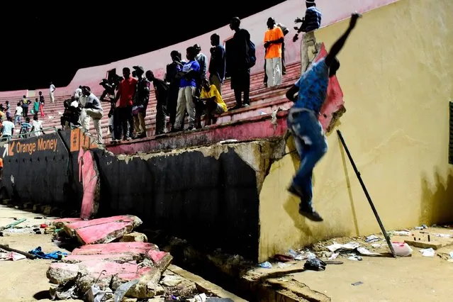 People look at the scene after a wall collapsed at Demba Diop stadium July 15, 2017 in Dakar, Senegal after a football game between local teams Ouakam and Stade de Mbour. Eight people were killed during Senegal's football league final in Dakar on Saturday in a stampede that broke out following clashes at the end of the match, the official APS news agency said. The wall collapse adding many more to be injured. (Photo by AFP Photo/APA/Seyllou)