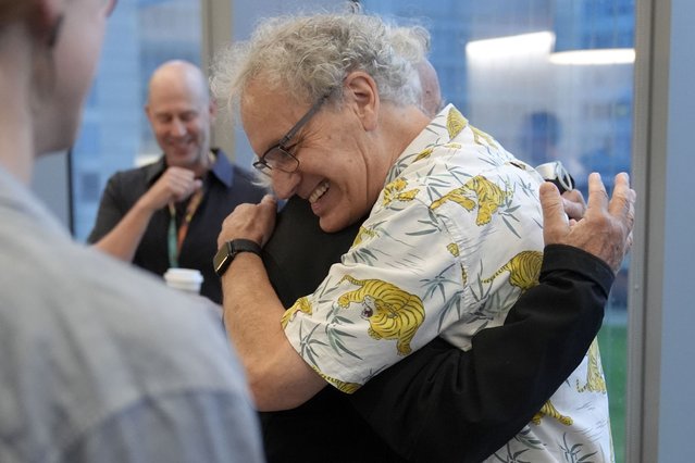 Victor Ambros, 2024 Nobel Prize winner in physiology or medicine, and professor of natural science at the University of Massachusetts Medical School, right, hugs colleague Allan Jacobson, at the school, in Worcester, Mass. Monday, October 7, 2024. (Photo by Steven Senne/AP Photo)