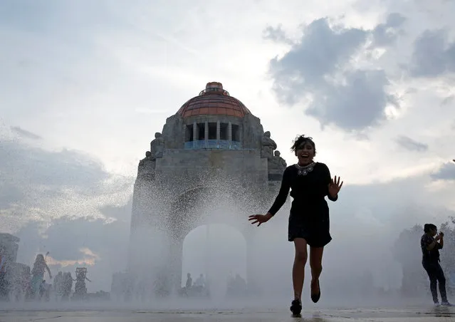 A  woman runs through a fountain at the Monument of the Revolution in Mexico City, Mexico August 5, 2017. (Photo by Henry Romero/Reuters)