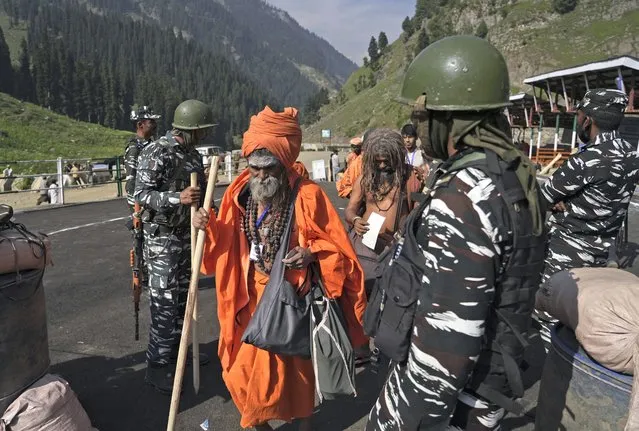 Soldiers stand guard as Hindu devotees begin the Amarnath Yatra annual pilgrimage to to an icy Himalayan cave, in Chandanwari, Pahalgam, south of Srinagar, Indian-controlled Kashmir, Thursday, June 30, 2022. Officials say pilgrims face heightened threat of attacks from rebels fighting against Indian rule and have for the first time tagged devotees with wireless tracking system. They also have deployed drones for surveillance. (Photo by AP Photo/Stringer)