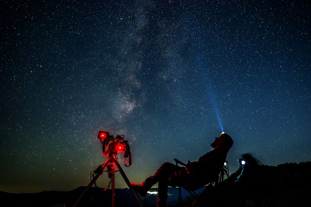 A member of the astronomical society sits by his cameras and watches the starry sky expecting to see and photograph a meteor, during the Perseid meteor shower over the lake of Kozjak, some 45km from the capitol Skopje, North Macedonia, 12 August 2024. (Photo by Georgi Licovski/EPA/EFE)