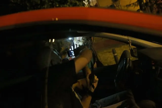 A zombie approaches a car during the “Survival Zombie” competition in Collado Villalba, outside Madrid, late September 6, 2014. According to the back-story of the “Survival Zombie” contest, participants, who signed up as survivors, are trapped for a night in a city that has been infected with a virus that causes humans to turn into zombies. (Photo by Susana Vera/Reuters)