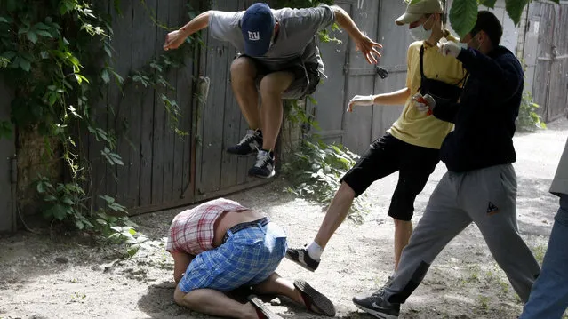 Unidentified people beat Svyatoslav Sheremet (L, bottom), head of Gay-Forum of Ukraine public organization, in Kiev, May 20, 2012. Sheremet was attacked after meeting with members of the media to inform them that a scheduled gay parade was cancelled. The attackers ran off when they realised members of the media were documenting the attack. (Photo by Anatolii Stepanov/Reuters)