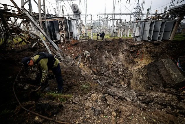 Investigators inspect a crater left by a Russian missile strike at an electrical transformer facility, amid Russia's attack on Ukraine, in Kharkiv, Ukraine on September 28, 2022. (Photo by Zohra Bensemra/Reuters)