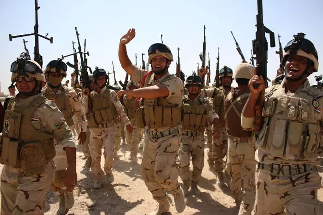Iraqi soldiers brandish their weapons during a military training exercise in the mainly Shiite southern city of Basra on September 14, 2014, before being deployed to the north of the city. Jihadist-led militants launched a major offensive last June in Iraq, overrunning large areas of five provinces and sweeping security forces aside. (Photo by Haidar Mohammed Ali/AFP Photo)