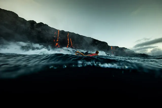 Alison Teal paddles out to Kilauea volcano in Hawaii as it eruopts into the ocean. (Photo by Perrin James/Caters News)