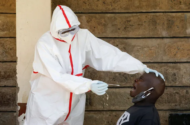 A man reacts as a health worker takes a swab during mass testing in an effort to stop the spread of the coronavirus disease (COVID-19), in Nairobi, Kenya on May 28, 2020. (Photo by Baz Ratner/Reuters)