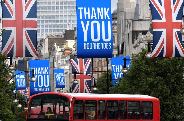 A bus is seen passing underneath Union Jack flags and banners with a message reading “Thank you #ourheroes” in Oxford Street, following the outbreak of the coronavirus disease (COVID-19), London, Britain, June 11, 2020. (Photo by Toby Melville/Reuters)