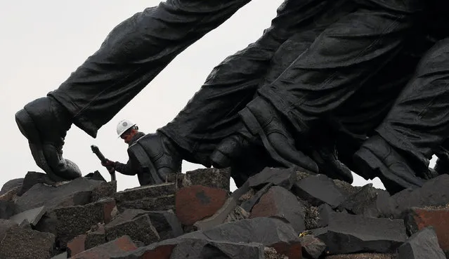A worker makes his way along the base of the U.S. Marine Corps War Memorial, commonly referred to as the Iwo Jima Memorial, during its multi-million dollar rehabilitation in Arlington, Virginia, U.S., November 13, 2017. (Photo by Kevin Lamarque/Reuters)