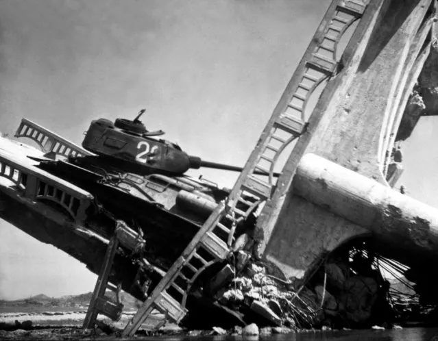 The wreckage of a bridge and North Korean Communist tank south of Suwon, Korea.  The tank was caught on a bridge and put out of action by the Air Force. October 7, 1950. (Photo by Marks, Army)