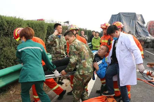 Rescuers carry an injured person on a stretcher after a highway accident in Fuyang in central China's Anhui province, Wednesday, November 15, 2017. (Photo by Chinatopix via AP Photo)