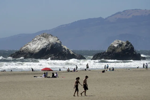 People visit Ocean Beach during the coronavirus outbreak in San Francisco, Sunday, July 5, 2020. Californians mostly heeded warnings to stay away from beaches and other public spaces during the long weekend as state officials urged social distancing amid a spike in coronavirus infections and hospitalizations. (Photo by Jeff Chiu/AP Photo)