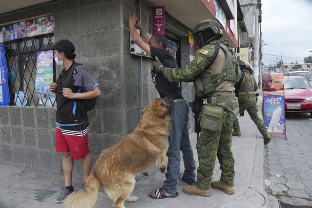 Soldiers stop a pedestrian to search for weapons as the man's dog jumps around, during military patrols in residential areas of northern Quito, Ecuador, Thursday, January 11, 2024. President Daniel Noboa decreed Monday a national state of emergency due to a wave in crime, a measure that lets authorities suspend people's rights and mobilize the military. The government also imposed a curfew. (Photo by Dolores Ochoa/AP Photo)