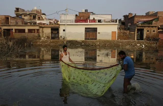 Indian villagers fish in stagnant water after flood waters receded in Allahabad, Uttar Pradesh state, India, Sunday, August 28, 2016. Flood water levels stabilized with rains ebbing over the past five days in this northern state, where 200,000 people had moved to relief centers after their homes were submerged. (Photo by Rajesh Kumar Singh/AP Photo)