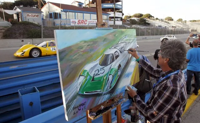 Official artist Bill Patterson paints while cars race past during the Porsche Rennsport Reunion V at Laguna Seca Raceway near Salinas, California, September 26, 2015. (Photo by Michael Fiala/Reuters)