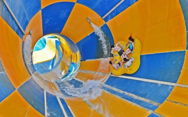 Tourists play at a water slide of 37 Degree Dream Sea Park on July 25, 2020 in Yantai, Shandong Province of China. (Photo by Sun Wentan/VCG via Getty Images)