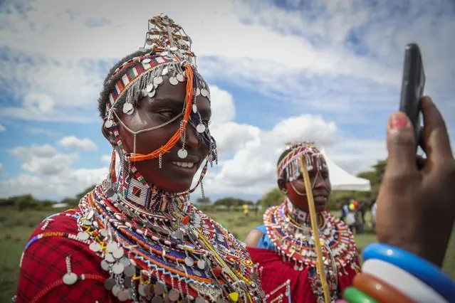 A Maasai woman takes a selfie as she prepares to watch the Maasai Olympics in Kimana Sanctuary, southern Kenya Saturday, December 10, 2022. The sports event, first held in 2012, consists of six track-and-field events based on traditional warrior skills and was created as an alternative to lion-killing as a rite of passage. (Photo by Brian Inganga/AP Photo)