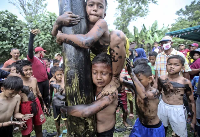 Children take part in a greased-pole climbing competition during the celebration of the 75th anniversary of the country's independence in Medan, North Sumatra, Indonesia, Monday, August 17, 2020. (Photo by Binsar Bakkara/AP Photo)