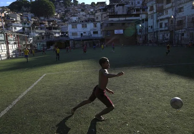 A boy attends a soccer training class at the Professor Mateia soccer school in the Morro da Mineira favela, Rio de Janeiro, Brazil, Friday, November 18, 2022. Brazil will go to this year's World Cup as the top-rated team after extending its lead over second-place Belgium in the latest FIFA rankings. The World Cup starts on Nov. 20. (Photo by Silvia Izquierdo/AP Photo)