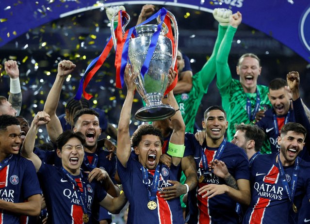 Paris St Germain's Marquinhos lifts the trophy as he celebrates with teammates after winning the Champions League final against Inter Milan, in Munich, Germany, on May 31, 2025. (Photo by Peter Cziborra/Reuters)