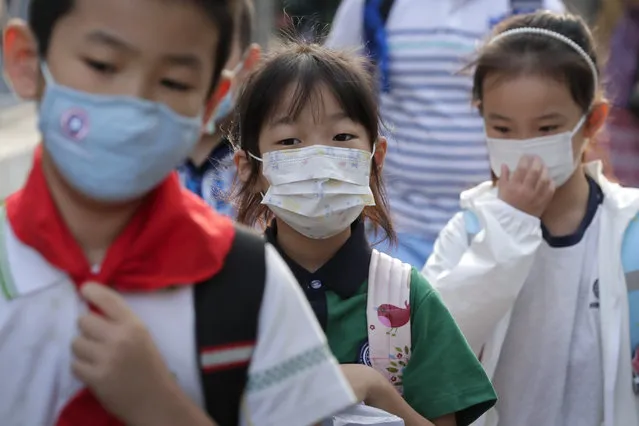 Students wearing face masks to help curb the spread of the coronavirus arrive at a primary school in Beijing, Monday, September 7, 2020. Students in the capital city returned to school on Monday in a staggered start to the new school year because of the coronavirus outbreak. (Photo by Andy Wong/AP Photo)