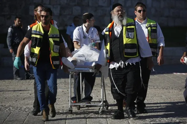 Members of a ZAKA emergency response team and emergency paramedics evacuate a wounded Palestinian attacker from the scene after he reportedly stabbed two Israeli police officers with a knife near the Damascus Gate in the Old City district of Jerusalem, 19 September 2016. According to the police, a 20-years-old Palestinian stabbed two Israeli police officers and wounded one of them, a policewoman, seriously. The other policeman then opened fire and seriously wounded the Palestinian attacker. (Photo by Abir Sultan/EPA)