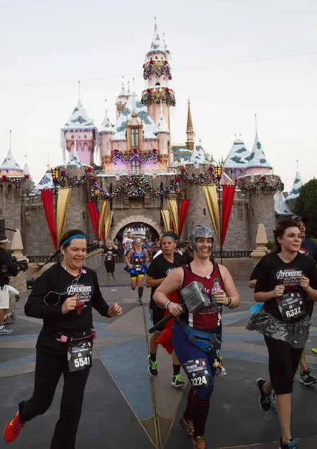 Runners in super hero outfits stream past Sleeping Beauty's Castle during the Avengers Super Heroes Half Marathon in and around the Disney Parks in Anaheim, California November 16, 2014. (Photo by Eugene Garcia/Reuters)
