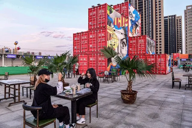 This photo taken on September 20, 2020 shows people visiting a shopping district made out of shipping containers in Shenyang in China's northeastern Liaoning province. (Photo by AFP Photo/China Stringer Network)