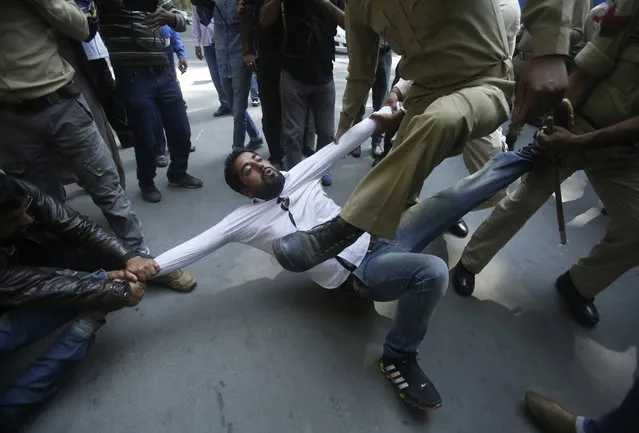 Indian policemen try to detain a supporter of Jammu and Kashmir state lawmaker, Engineer Abdul Rashid Sheikh, during a protest in Srinagar, Indian controlled Kashmir, Monday, September 26, 2016. Kashmir is witnessing the largest protests against Indian rule in recent years, sparked by the July 8 killing of a popular rebel commander by Indian soldiers. The protests, and a sweeping security crackdown, have all but paralyzed life in Indian-controlled Kashmir. (Photo by Mukhtar Khan/AP Photo)